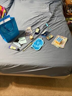 Blue beauty bag with various items for body care, face, jewelry,makeup. Lip balm